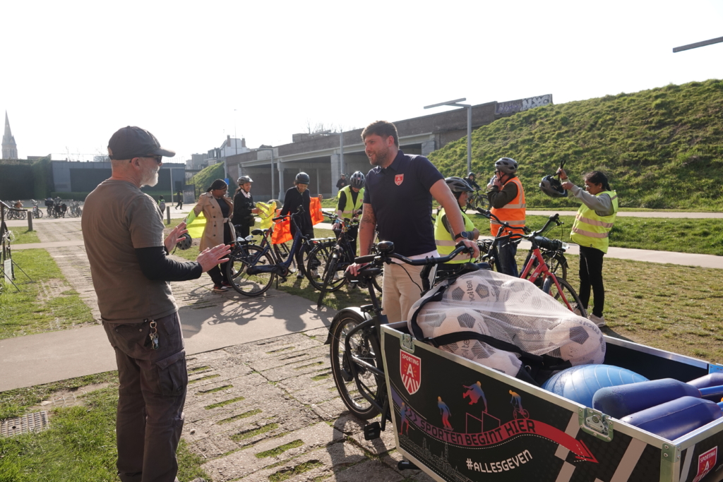 Axl in de wijk met zijn bakfiets vol sportmateriaal